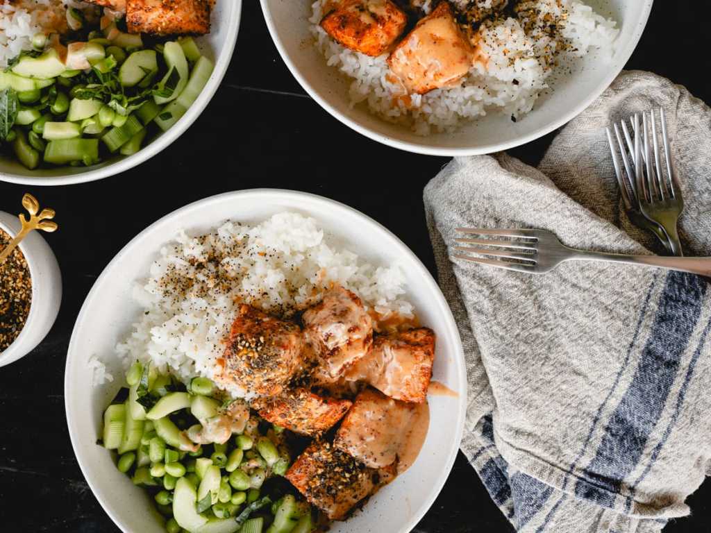 Roasted salmon rice bowls with bang bang sauce and crispy cucumber salad.